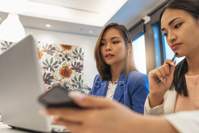 Красивые молодые азиатские женщины, работающие вместе в современном офисе — стоковое фото