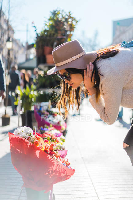 Молода приваблива азіатська жінка дивиться на квіти в магазині — стокове фото