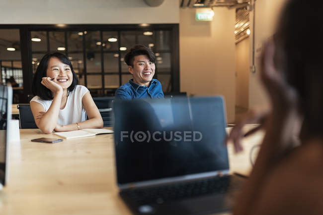 Young asian people at work with laptop in modern office — Stock Photo