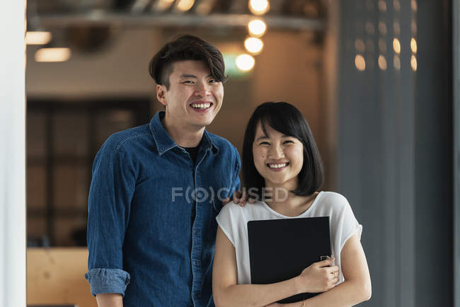 Dos jóvenes asiáticos en oficina moderna con documentos - foto de stock