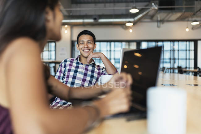 Двое молодых азиатов за работой с ноутбуком в современном офисе — стоковое фото