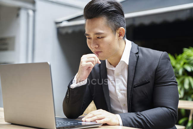 Junge asiatische erfolgreiche Geschäftsmann mit Laptop — Stockfoto
