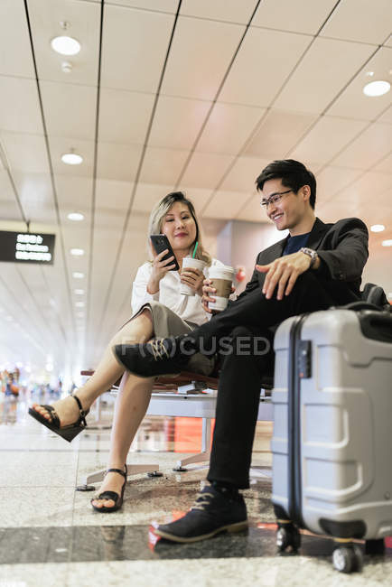 Успешная бизнес-азиатская пара вместе с кофе в аэропорту — стоковое фото