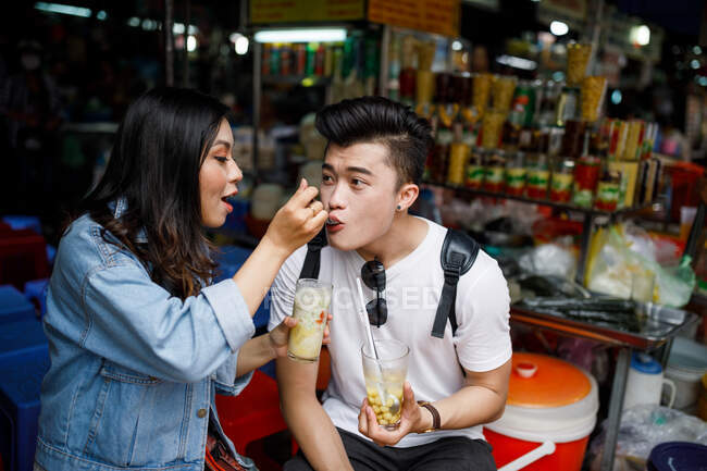 Jovem casal a comer a sobremesa em uma banca de comida local na cidade de Ho Chi Minh, Vietnã. — Fotografia de Stock