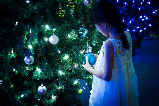 Feliz asiática chica jugando con burbuja cerca de abeto en parque de atracciones en Navidad - foto de stock