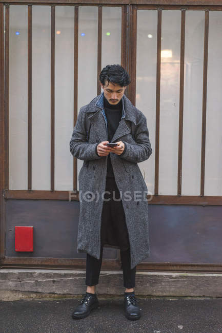 Homem elegante moda usando smartphone na rua da cidade — Fotografia de Stock