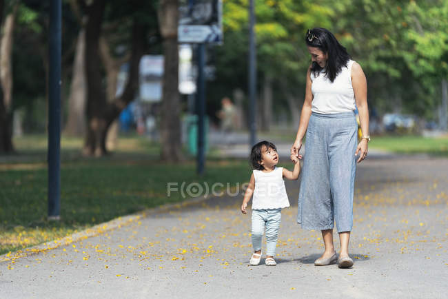 Cute adorable asian little girl in park with mother — Stock Photo