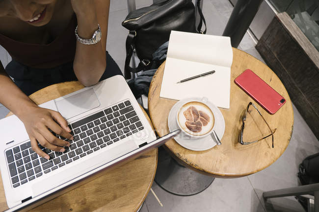 Immagine ritagliata di giovane attraente donna asiatica utilizzando il computer portatile in caffè — Foto stock