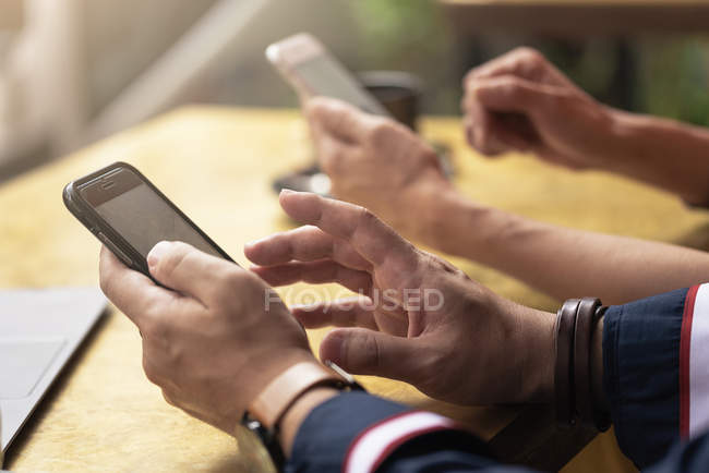 Cropped image of couple using smartphones — Stock Photo