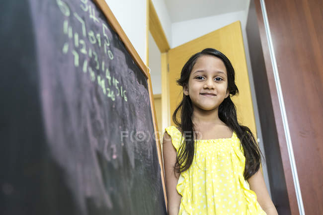 Jovem pouco bonito asiático menina no escola ao lado giz bordo — Fotografia de Stock