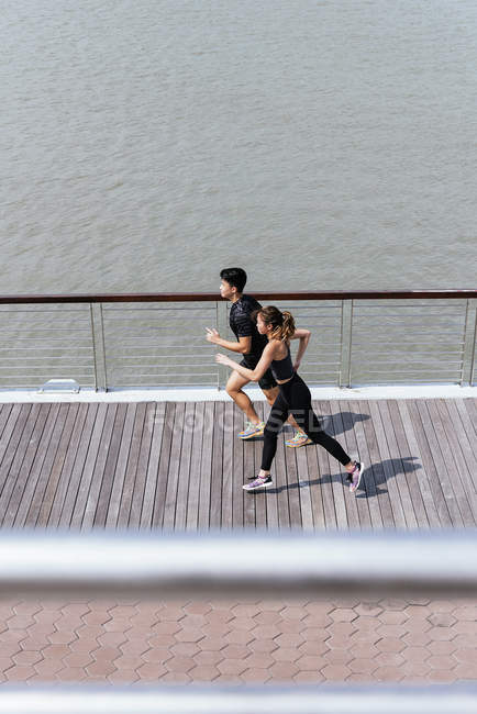 Elevated view of asian couple running together — Stock Photo