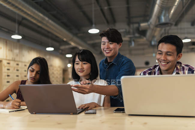 Молоді азіатські бізнесмени працюють разом в сучасному офісі — стокове фото