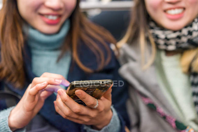 Молоді випадкові азіатські дівчата використовують смартфон у місті — стокове фото
