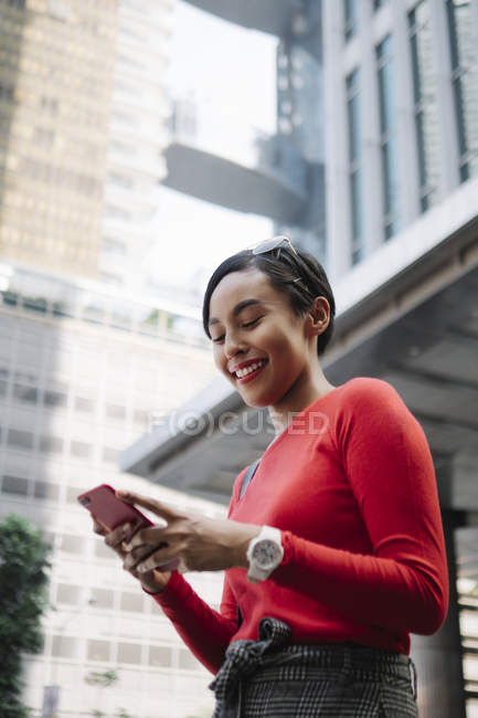 Jeune asiatique attrayant femme en utilisant smartphone sur ville rue — Photo de stock