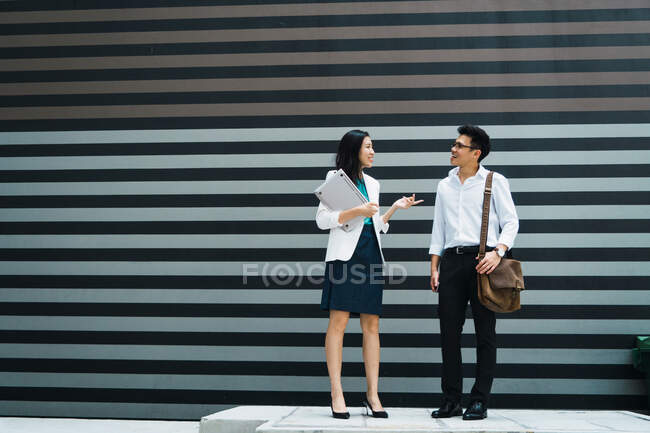 Jovem asiático negócio casal posando ao lado de escritório — Fotografia de Stock
