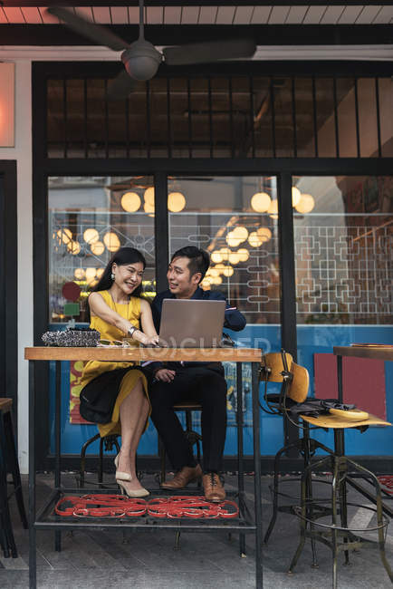 Heureux asiatique jeune couple ensemble en utilisant ordinateur portable dans café — Photo de stock