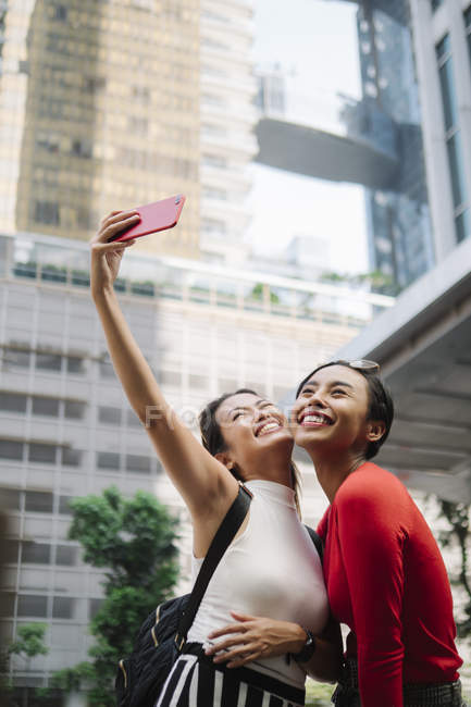 Giovani asiatico femmina amici insieme prendendo selfie su città strada — Foto stock