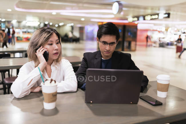 Erfolgreiches asiatisches Paar arbeitet mit Laptop am Flughafen — Stockfoto