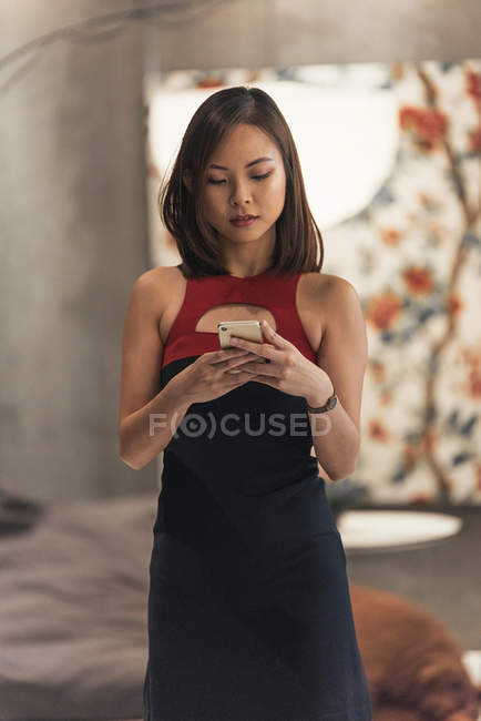 Красива молода азіатська жінка використовує смартфон — стокове фото