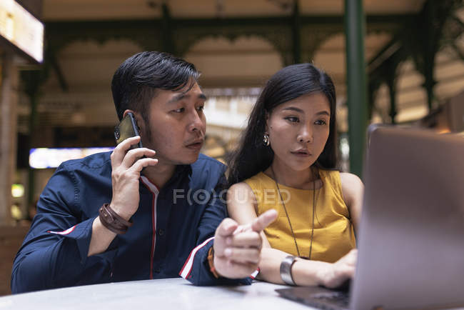 Happy asian young couple together using laptop in cafe — Stock Photo