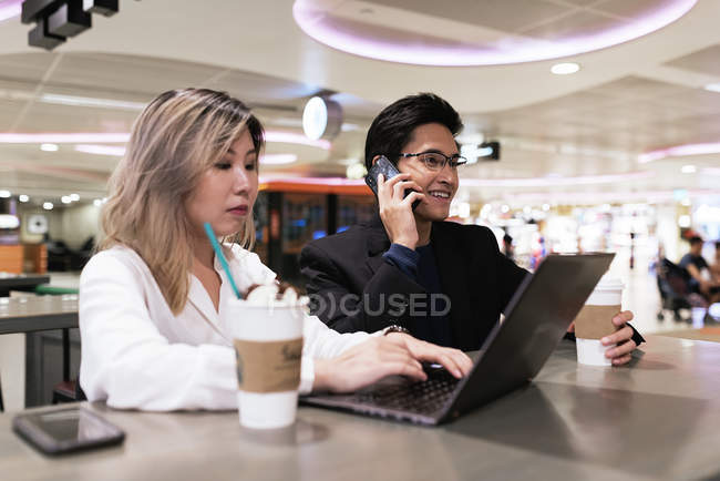 Erfolgreiches asiatisches Paar arbeitet mit Laptop am Flughafen — Stockfoto