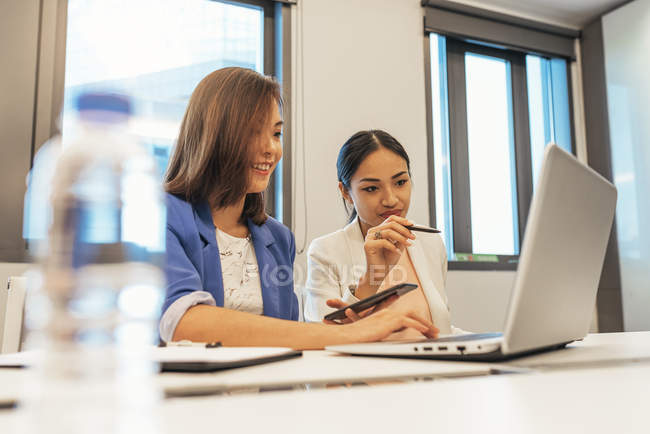 Beautiful young asian women working together in modern office — Stock Photo
