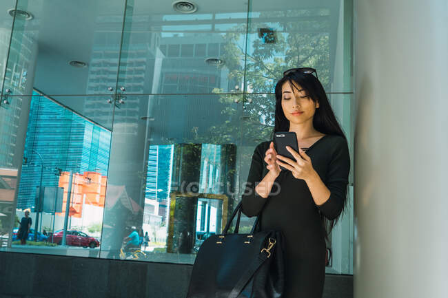 Jovencita mujer de negocios asiática con teléfono celular - foto de stock