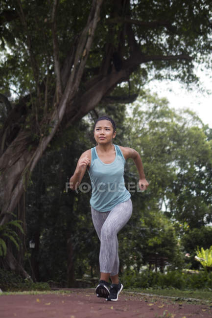 Молода азіатська спортивна жінка біжить в парку — стокове фото