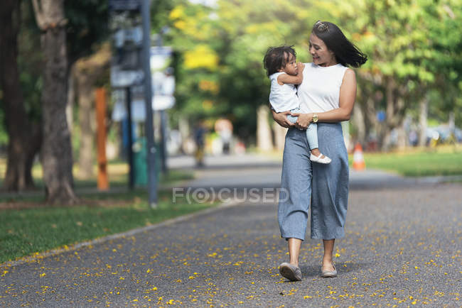 Милая очаровательная азиатская маленькая девочка в парке с мамой — стоковое фото