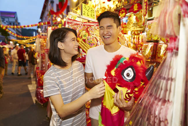 Young asian couple spending time together on traditional bazaar at Chinese New Year — Stock Photo