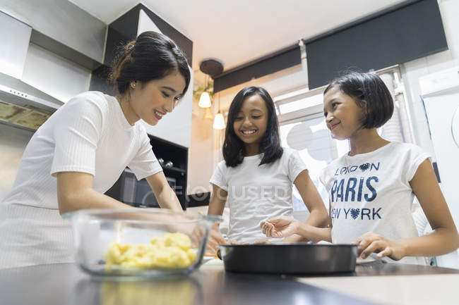 Happy asian family celebrating hari raya at home and cooking at kitchen — Stock Photo