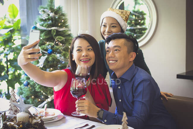 Сінгапурська пару користується святковий обід з другом в красивий будинок під час різдвяних свят. — стокове фото