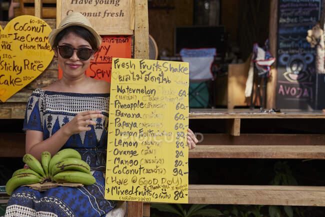 РЕЛИЗ Молодая женщина позирует с меню в кафе на Ко Куд, Таиланд — стоковое фото