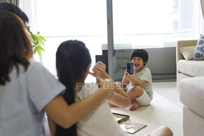 Heureux jeune asiatique famille ensemble garçon prendre photo à la maison — Photo de stock