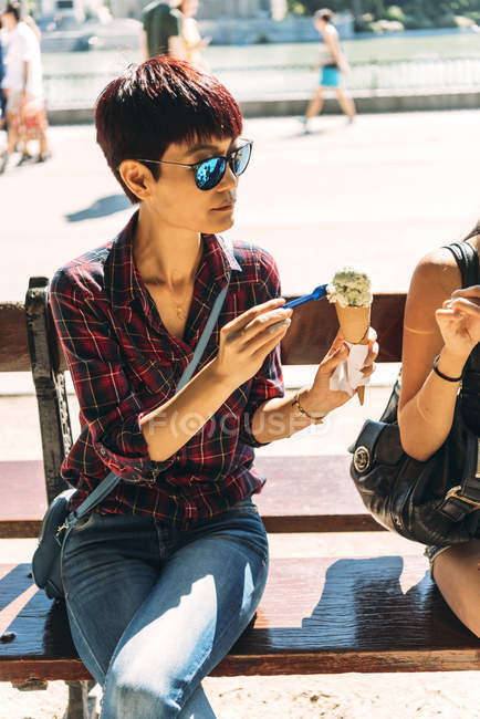 Азіатський жінка їсть морозиво гарячі сонячний день — стокове фото