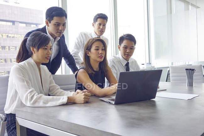 Jovem asiático pessoas de negócios trabalhando com laptop no escritório moderno — Fotografia de Stock