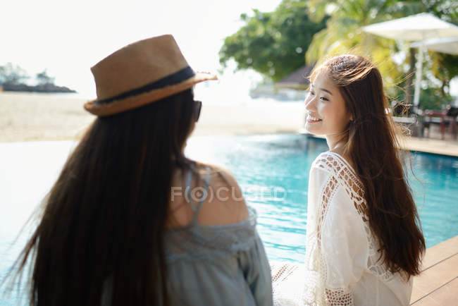 Belle giovani donne asiatiche rilassante vicino piscina — Foto stock