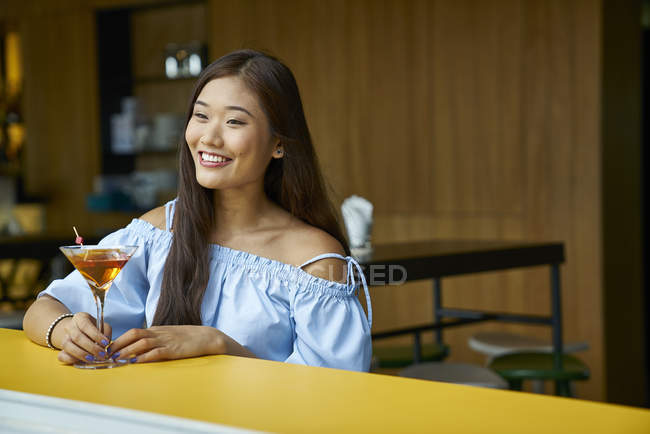 Attractive young asian woman with drink in cafe — Stock Photo