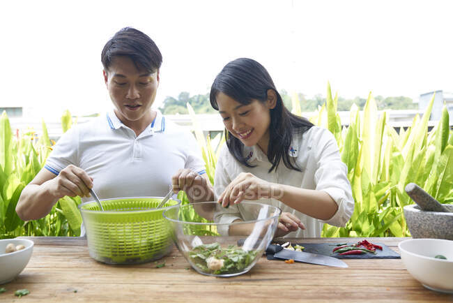 Happy young asian couple eating together in cafe — Stock Photo