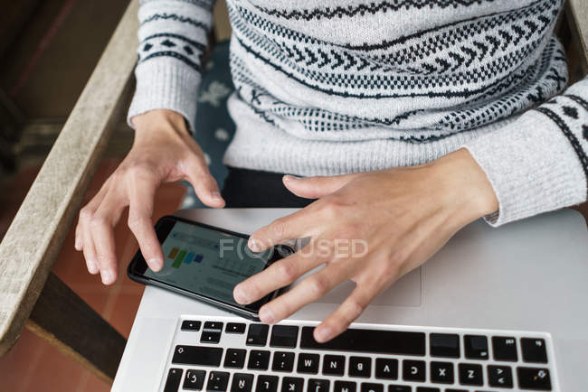Cropped image of young adult man using smartphone at home — Stock Photo