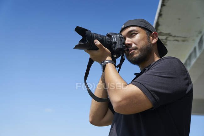 Молодой человек фотографирует с камерой — стоковое фото