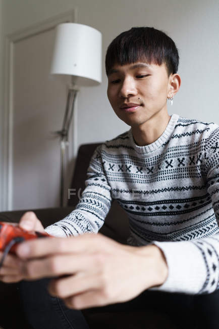 Young adult asian man playing video games — Stock Photo