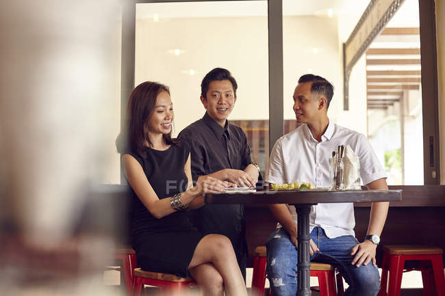 Felice giovani amici asiatici insieme nel bar — Foto stock
