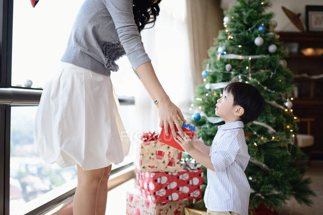 Mère heureuse donnant cadeau à son fils pour Noël — Photo de stock