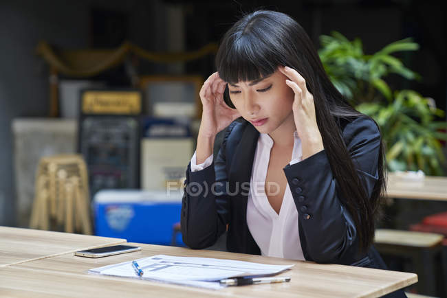 Gestresste junge attraktive asiatische Geschäftsfrau arbeitet im Café — Stockfoto