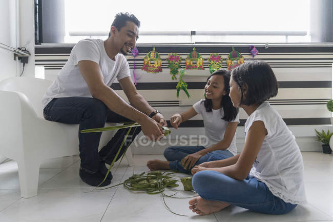 Happy asian family celebrating hari raya at home and preparing decorations — Stock Photo