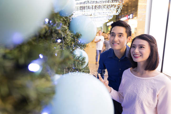 Giovane attraente asiatico coppia insieme shopping in centro commerciale a natale — Foto stock
