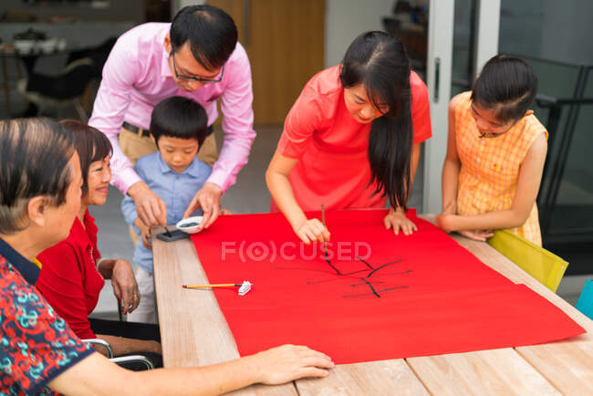 Felice famiglia asiatica disegno calligrafia geroglifici — Foto stock
