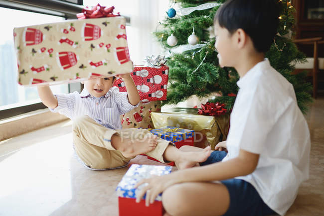 Feliz asiático hermanos celebrando Navidad juntos en casa - foto de stock