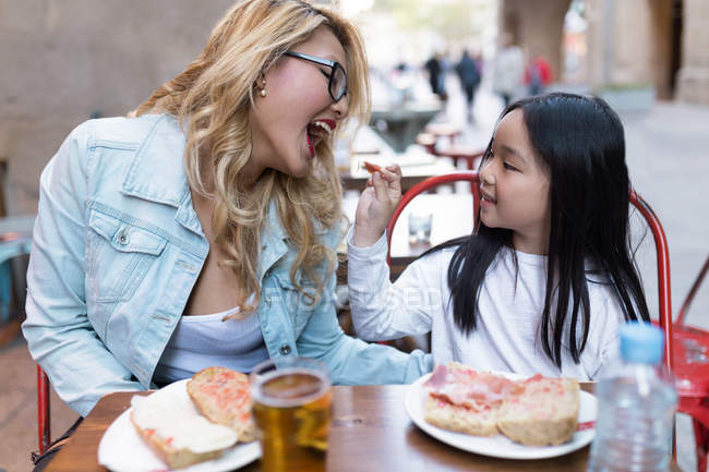 Chinesisches Mädchen füttert ihre Mutter mit Lebensmitteln — Stockfoto